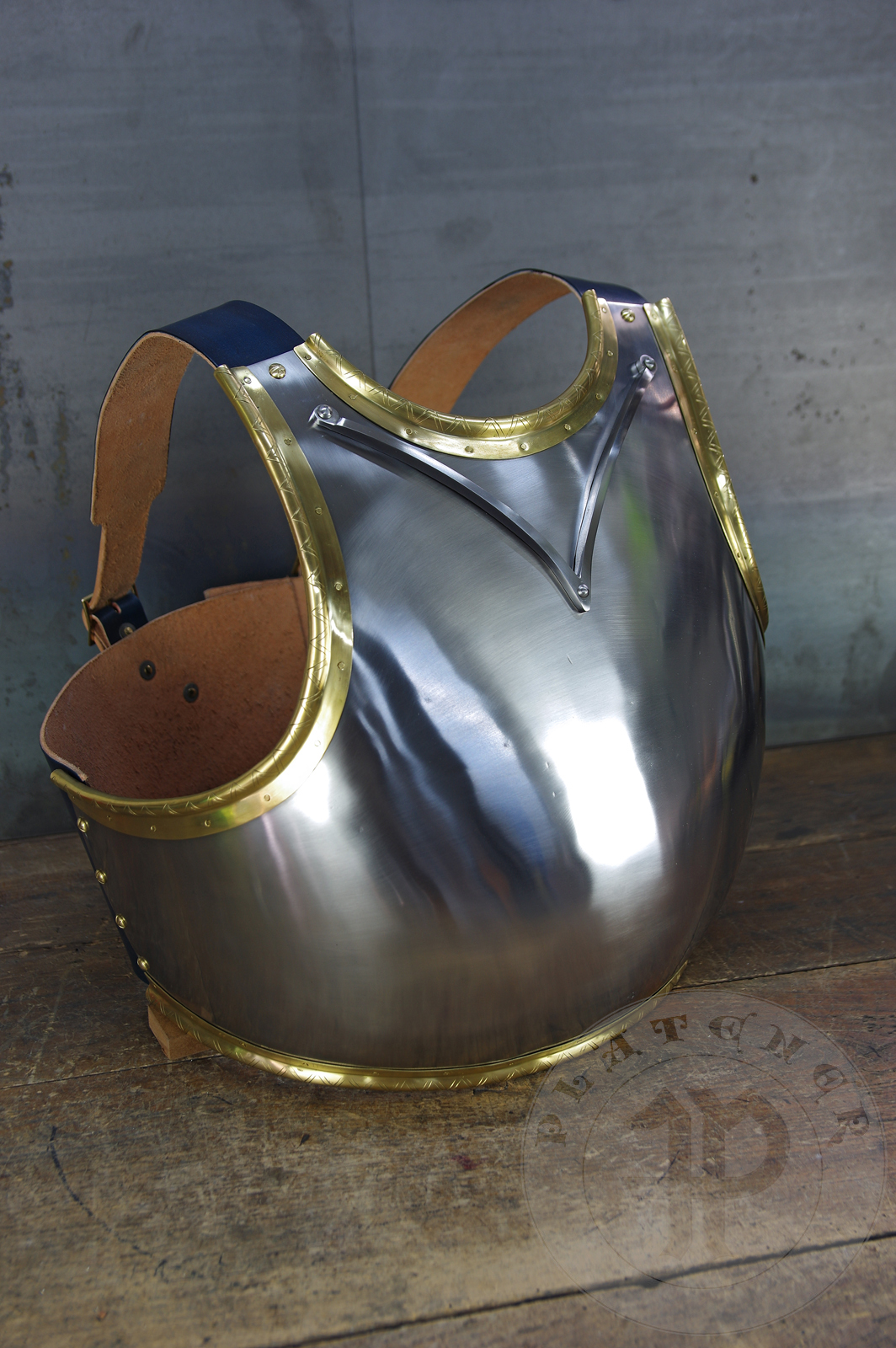 Here is a classic breastplate with V-neck stop rib (to deflect thrusts away from the neck) based on Churburg CH14. I enhanced its simple aesthetic by adding brass decorations around the edges with a geometrical, hand filed pattern. They were inspired by decorations from Churburg CH13 segmented breastplate and depictions in art from this period