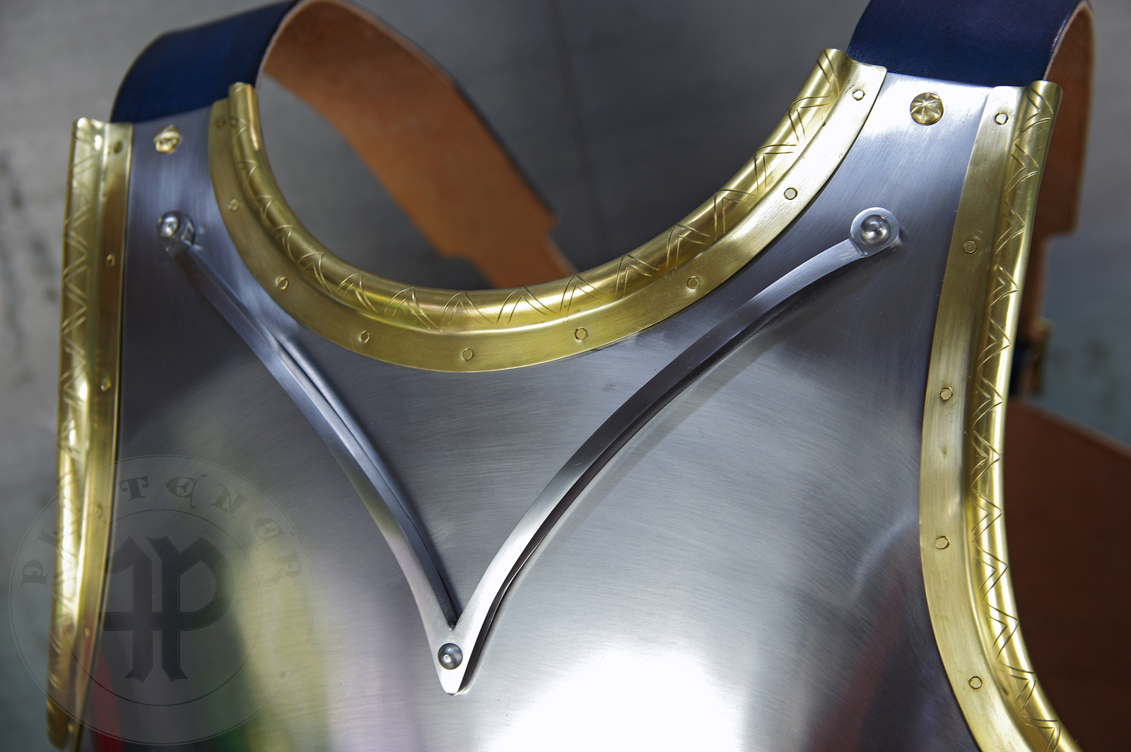 Here is a classic breastplate with V-neck stop rib (to deflect thrusts away from the neck) based on Churburg CH14. I enhanced its simple aesthetic by adding brass decorations around the edges with a geometrical, hand filed pattern. They were inspired by decorations from Churburg CH13 segmented breastplate and depictions in art from this period