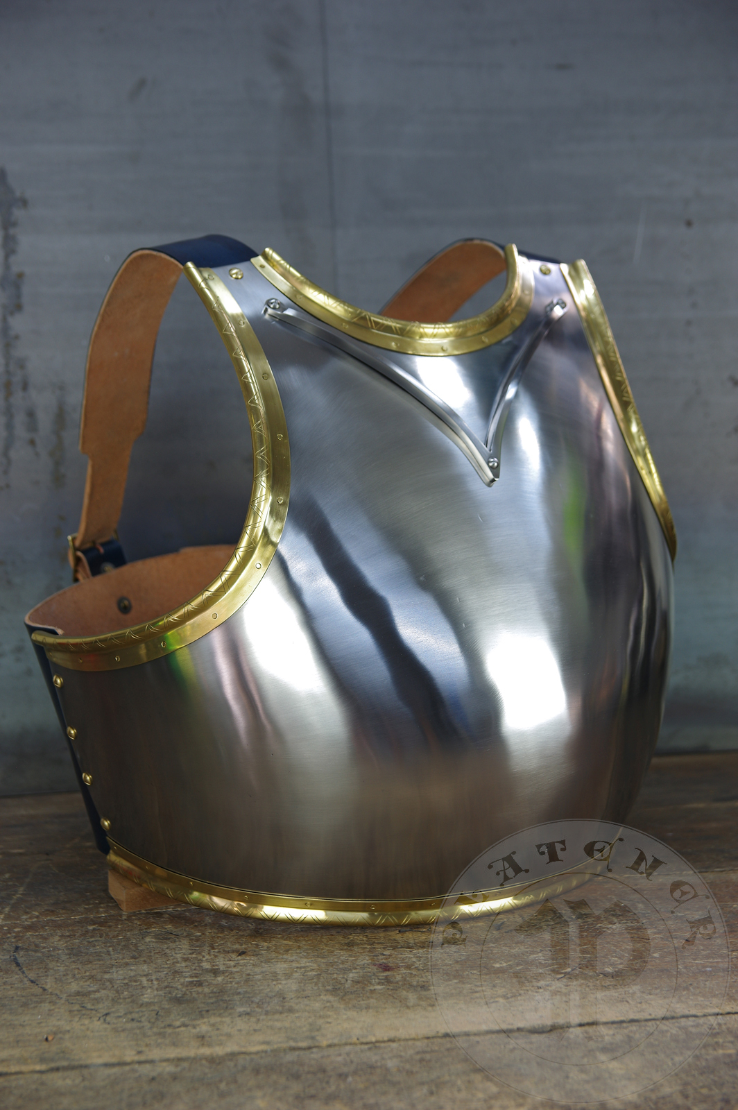 Here is a classic breastplate with V-neck stop rib (to deflect thrusts away from the neck) based on Churburg CH14. I enhanced its simple aesthetic by adding brass decorations around the edges with a geometrical, hand filed pattern. They were inspired by decorations from Churburg CH13 segmented breastplate and depictions in art from this period