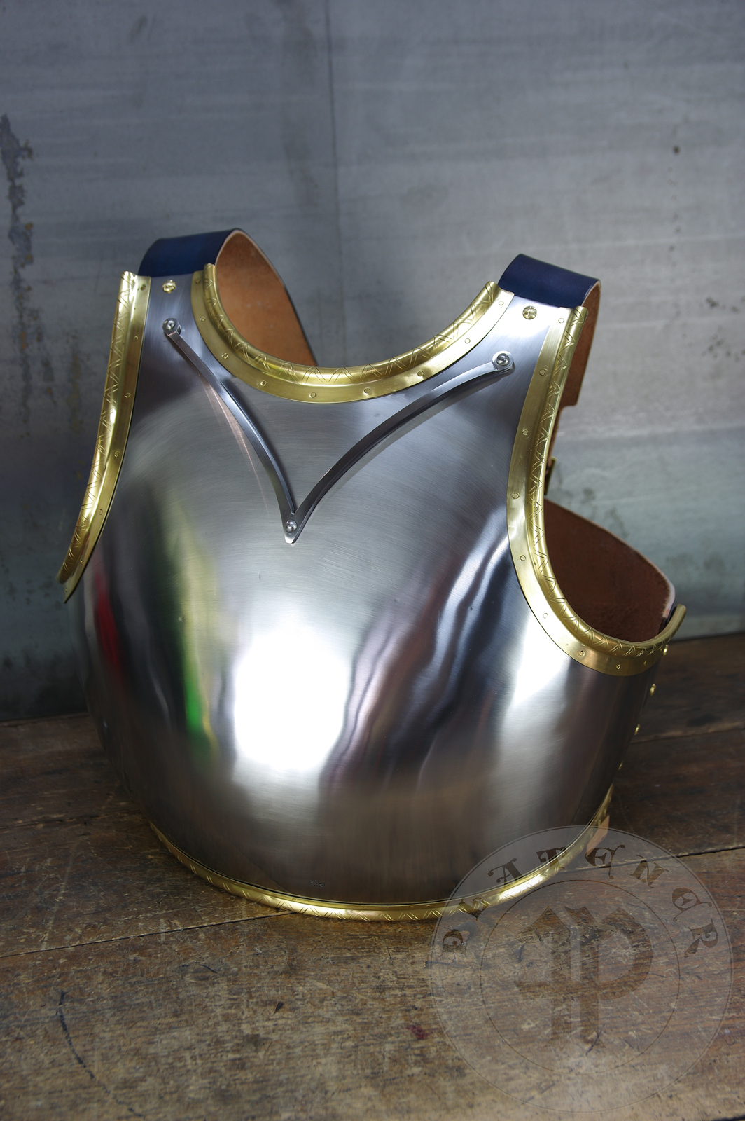 Here is a classic breastplate with V-neck stop rib (to deflect thrusts away from the neck) based on Churburg CH14. I enhanced its simple aesthetic by adding brass decorations around the edges with a geometrical, hand filed pattern. They were inspired by decorations from Churburg CH13 segmented breastplate and depictions in art from this period